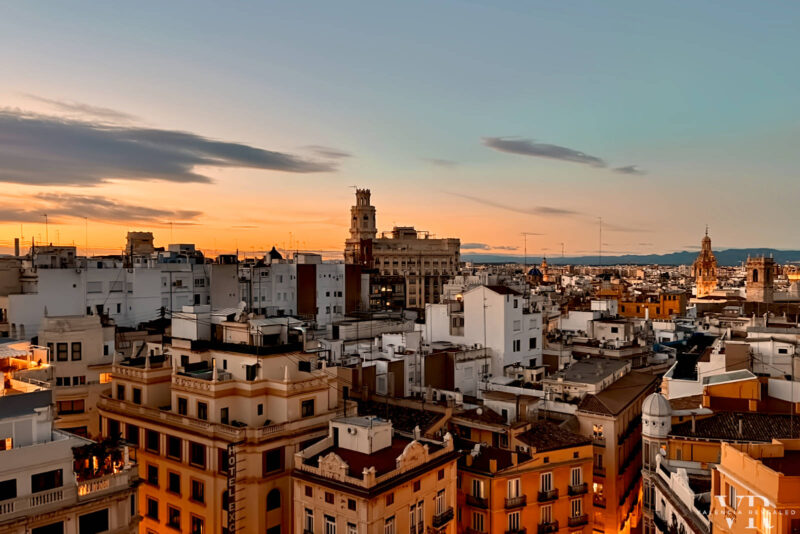 Sunset over Valencia's rooftops with a mixture of white and colorful buildings