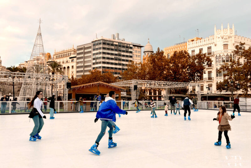 People skating on the ice rink in front of Valencia's City Hall