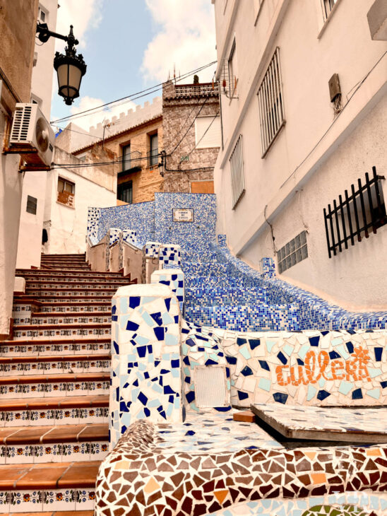 A colorful staircase covered in broken tiles in Barrio del Pou in Cullera