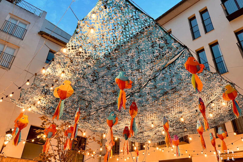 A street pergola with colorful hanging fish