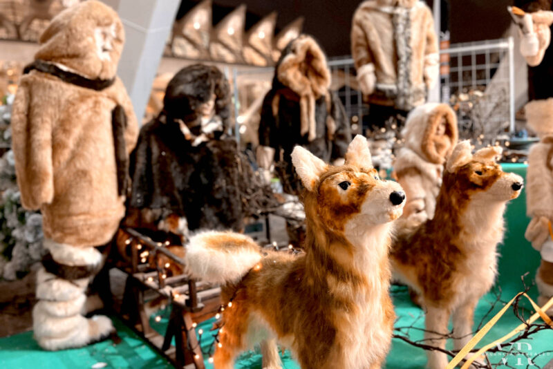 Puppets of two dogs pulling an slay and Esquimos dressed in furs