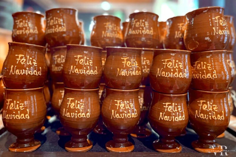 A pile of mulled wine glasses with the text "Feliz Navidad"