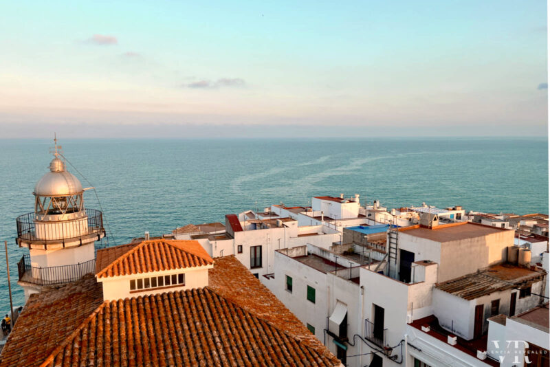 A lighthouse and whitewashed houses with the sea in the background in Peñiscola