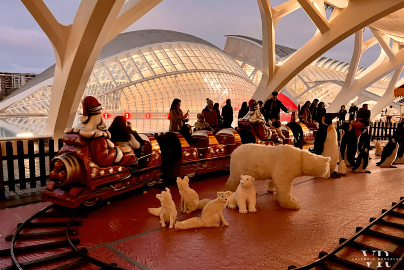 A Christmas market train for kids going around a family of polar bear puppets with the Hèmisferic building in the background