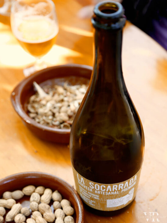 A bottle of La Socarrada beer and peanuts in shell