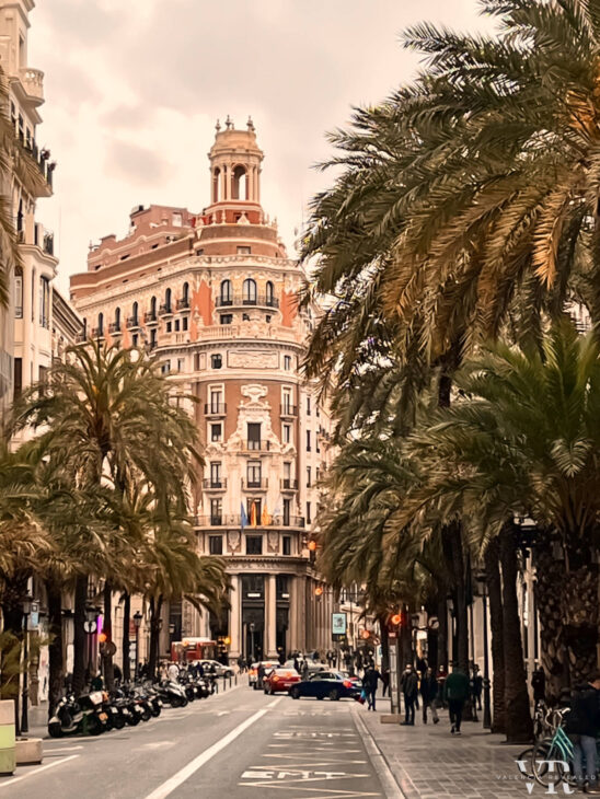 Palm tree lined street with a beautiful building at the end