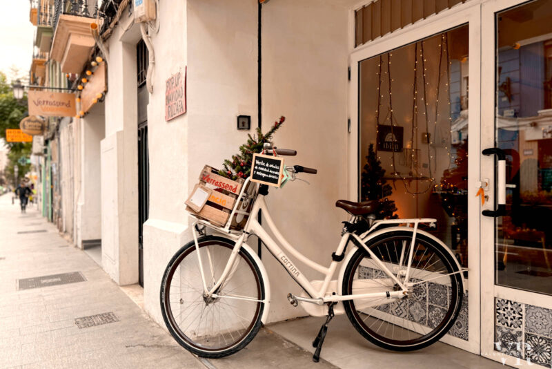 A white bike in front of a bike rental shop in Valencia
