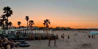 Beach club and palm trees at sunset