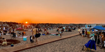 A crowded beach at sunset