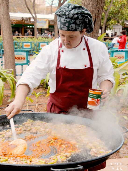 A chef cooking paella in the park